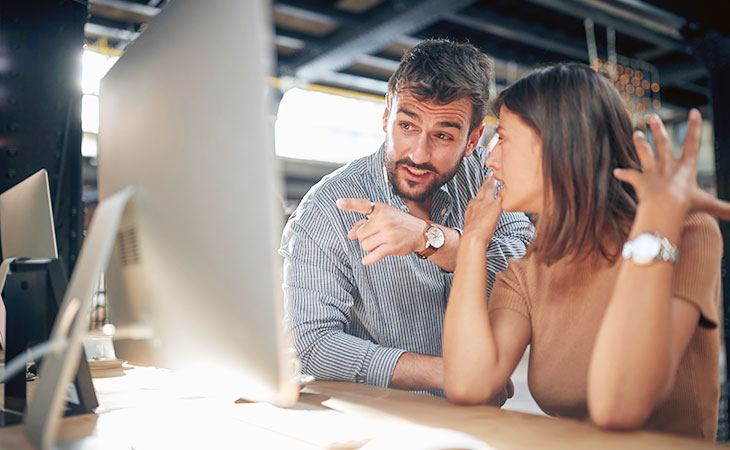 two people talking with a computer