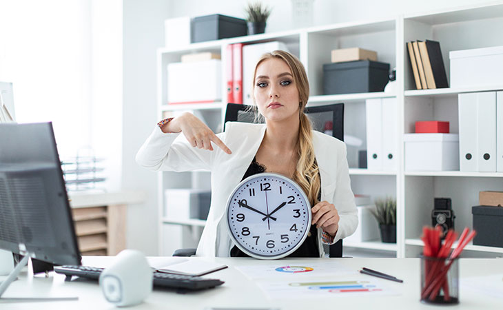 women pointing to big clock