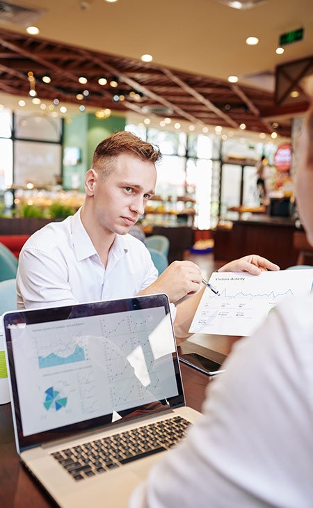 100+ Interview Questions For Product Managers + Answers Independent Recruiter LLC | Staffing Agency two-workers-discussing-statistics-laptop