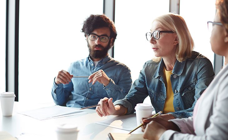 100+ Interview Questions For Product Managers + Answers Independent Recruiter LLC | Staffing Agency workers-talking-meeting-table