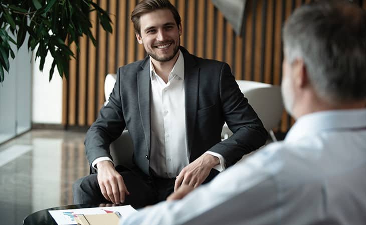 smiling man talking to another man