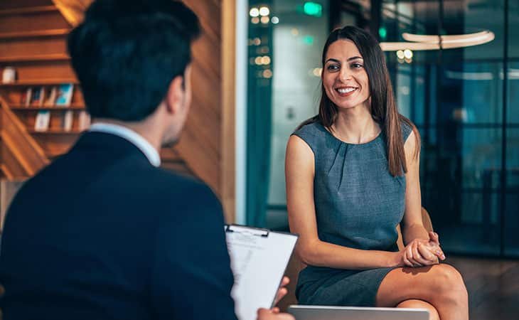 smiling woman talking to a man in a suit