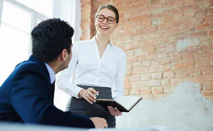 smiling woman with a book in her hands and a man