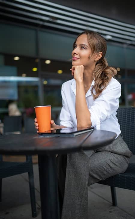 woman thinking with her hand in her chin, having coffee